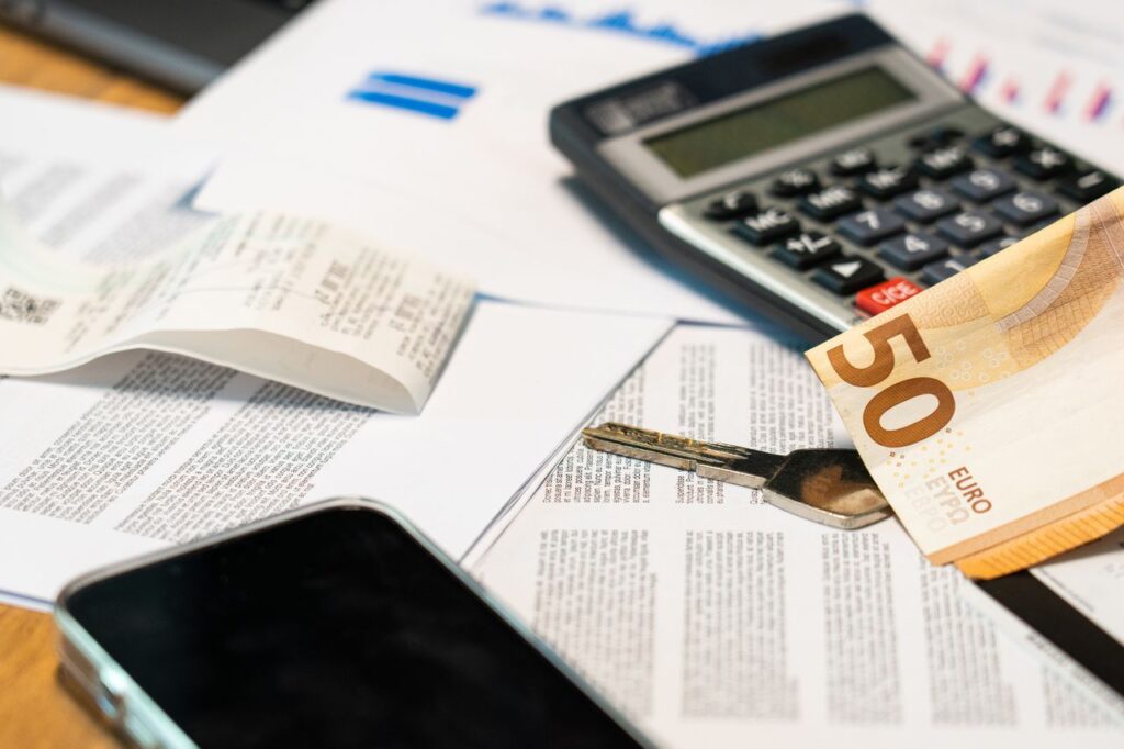 The Art of Drawing Readers In: Your attractive post title goes here Flat lay of financial documents, euro note, calculator, smartphone, and key for budget management.